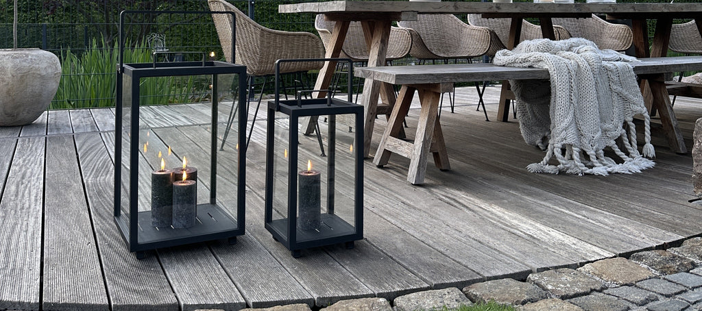 Outdoor lanters with cozy grey candle lights on the patio 