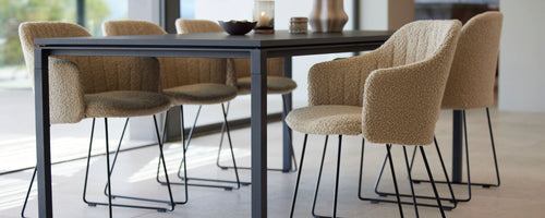 Stylish dining chairs with a woven texture and sleek black legs surrounding a modern table, enhancing the dining experience.