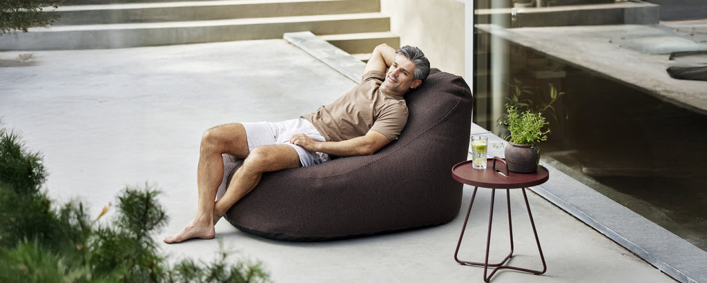 Brown bean bag and side table in a modern lounge setting.