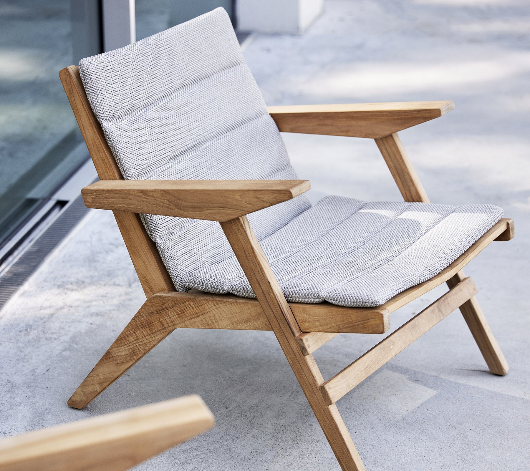 Stylish lounge chair with wooden frame and cushioned seat, designed for comfort and relaxation.