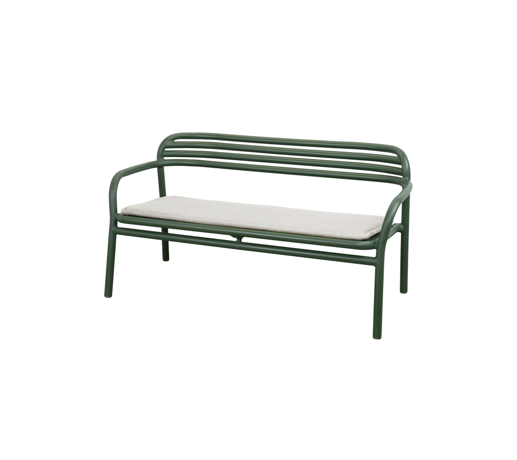 Dark green bench with sand cushion in a modern lounge setting.