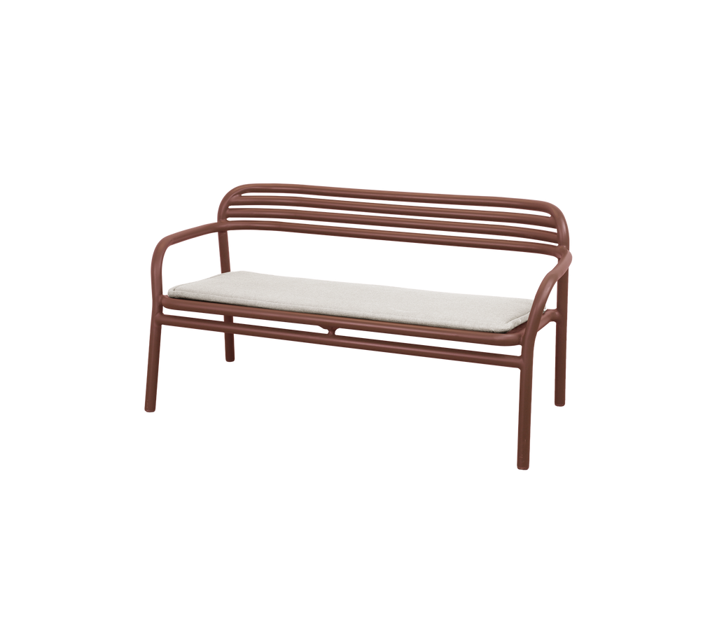 Modern bench in desert red with a beige cushion.