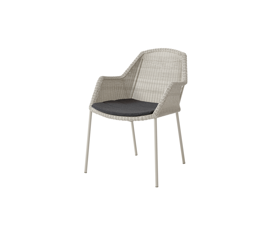 Light-colored chair with a black cushion.