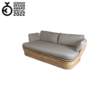 Contemporary sofa with a woven base and plush gray cushions, featuring a sleek design and elegant aesthetic. Awarded in 2022.