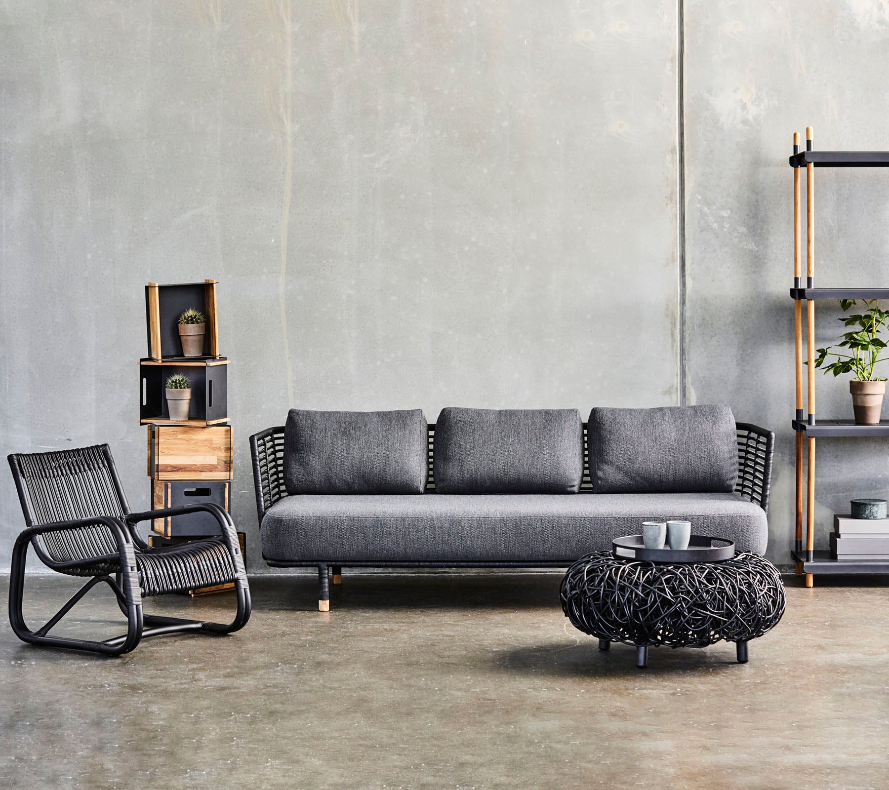 Modern living room setup featuring a sleek sofa, a textured coffee table, and a stylish accent chair, complemented by decorative shelves.