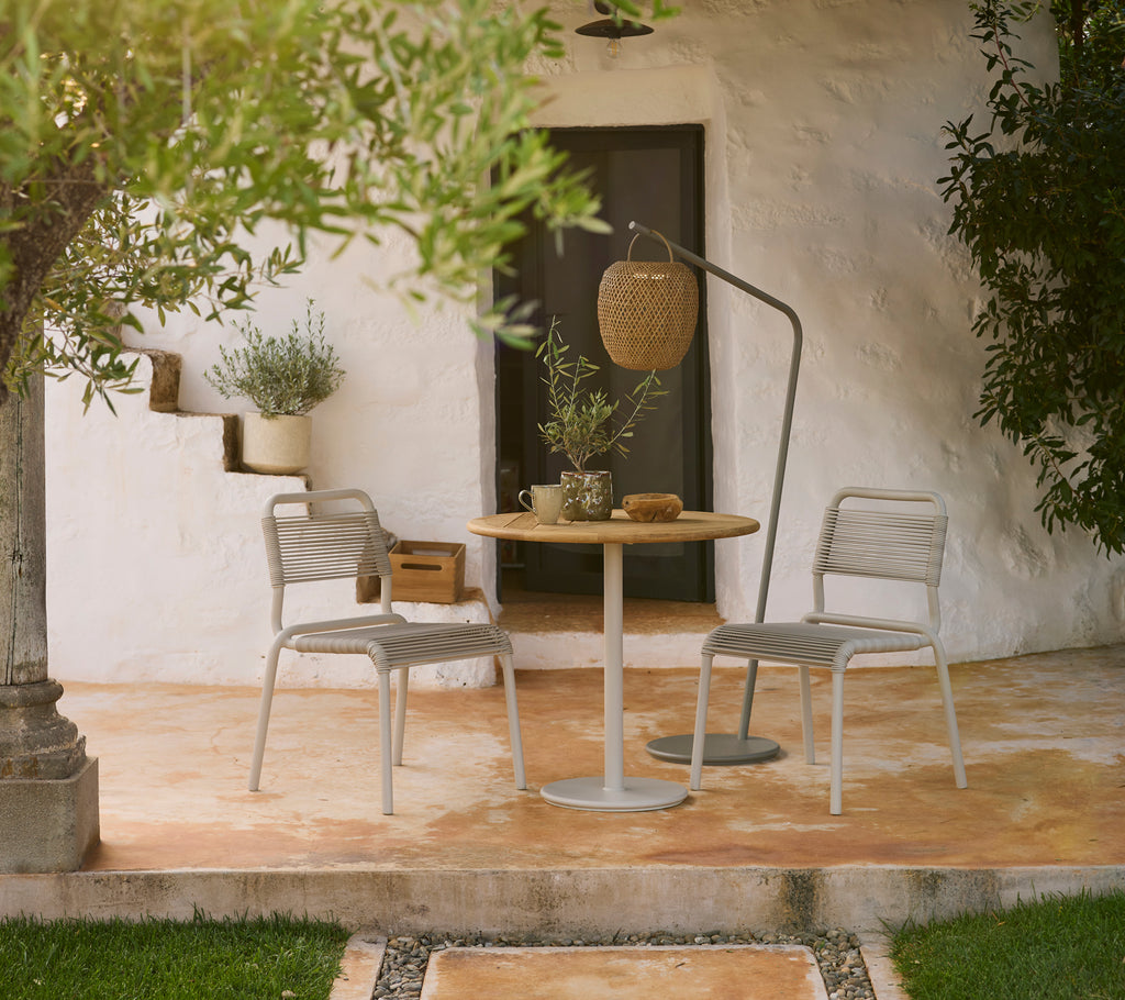 Modern grey chairs and round table in an outdoor setting.