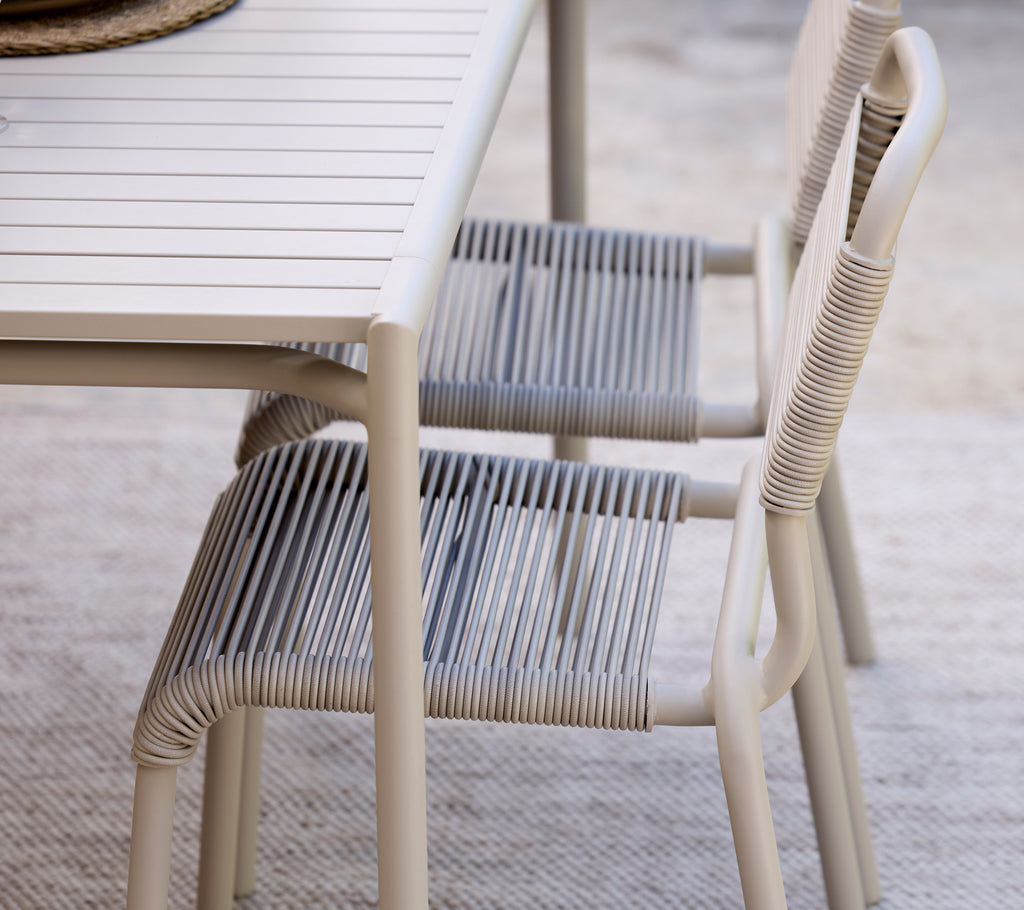 Modern grey dining table paired with striped chairs.