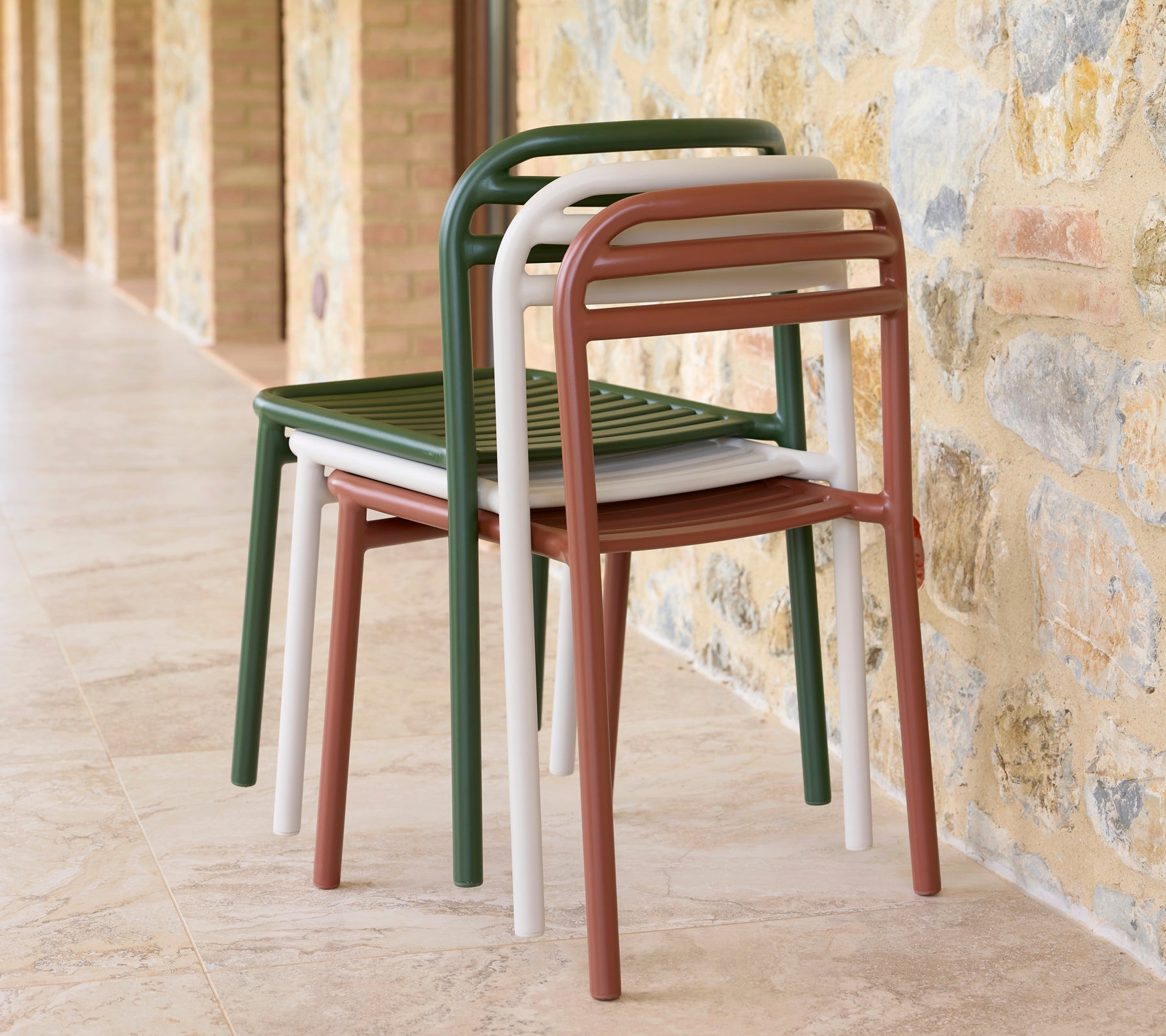 A stack of Bliss chairs in various colors, showcasing sleek design and practicality for space-saving storage.
