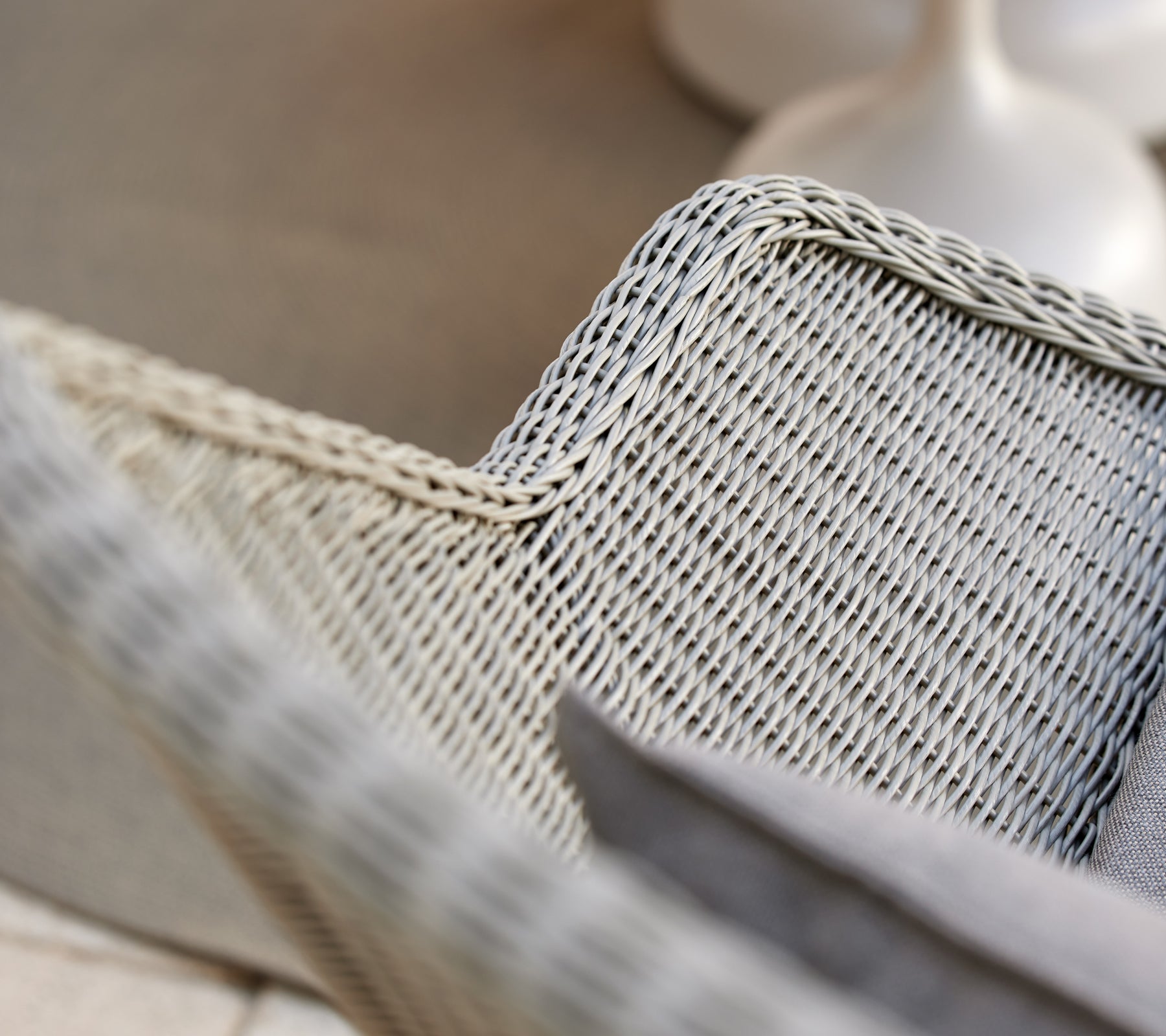 Grey woven lounge chair with a grey cushion.