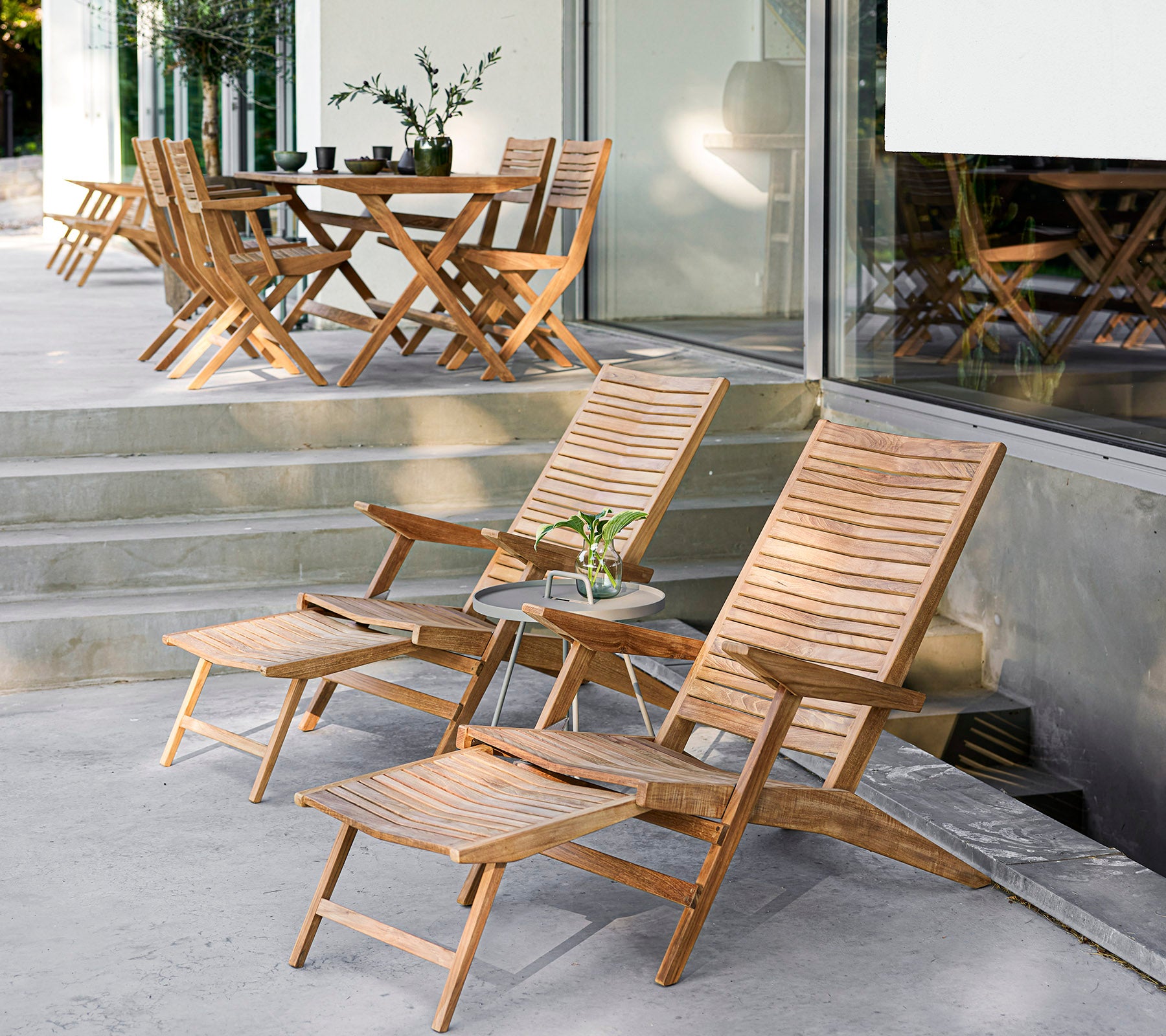 Stylish wooden furniture set featuring reclining chairs, a side table, and a dining table, perfect for cozy gatherings and relaxation.