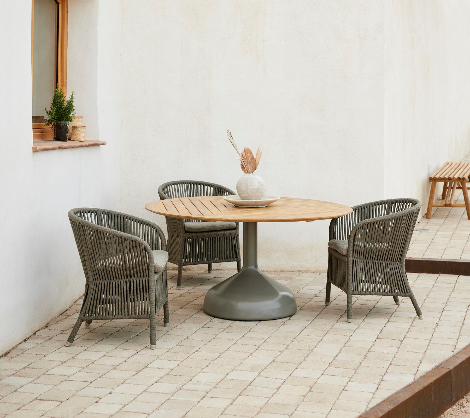 A stylish dining setup featuring a round wooden table surrounded by elegant Derby chairs, creating an inviting atmosphere.