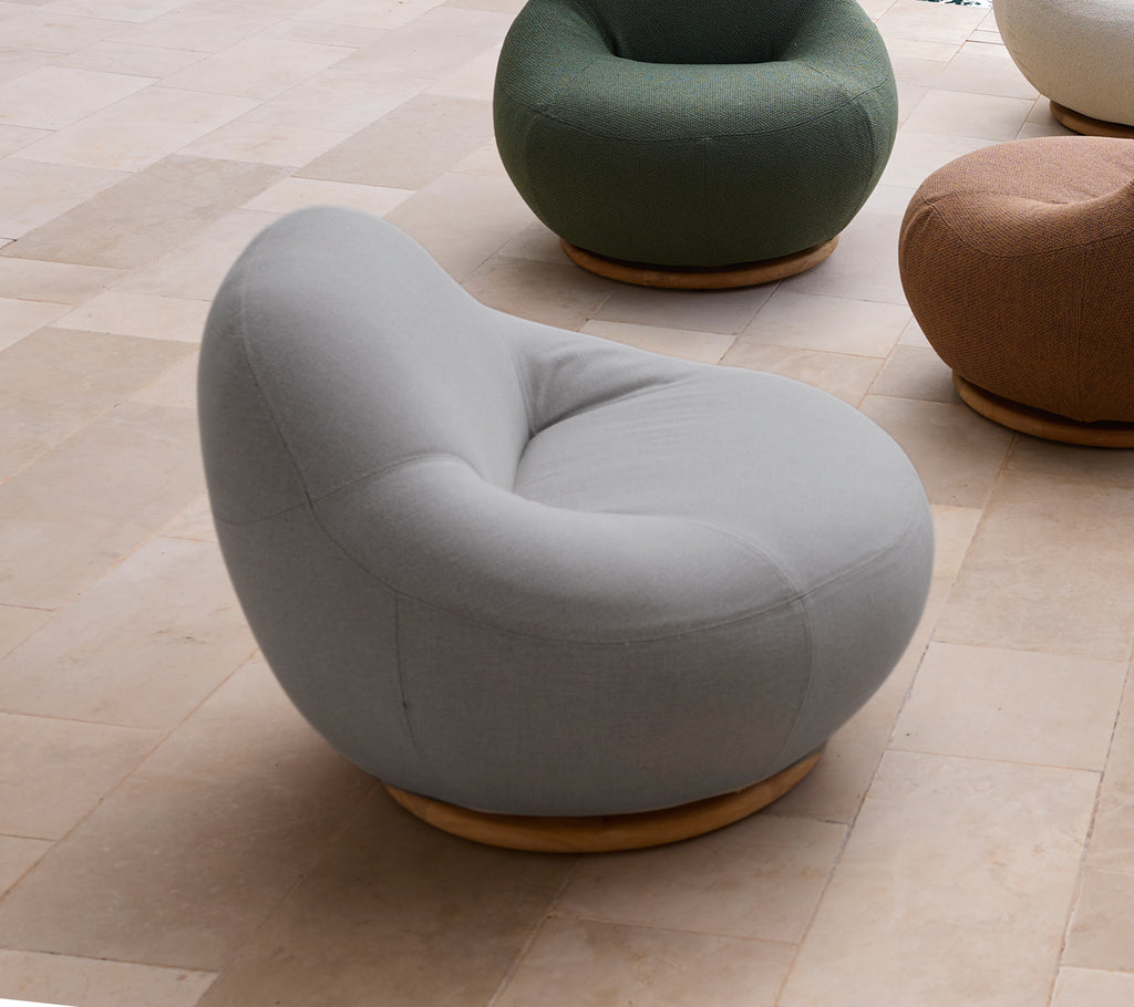 Modern grey chair with a rounded design in a lounge setting.