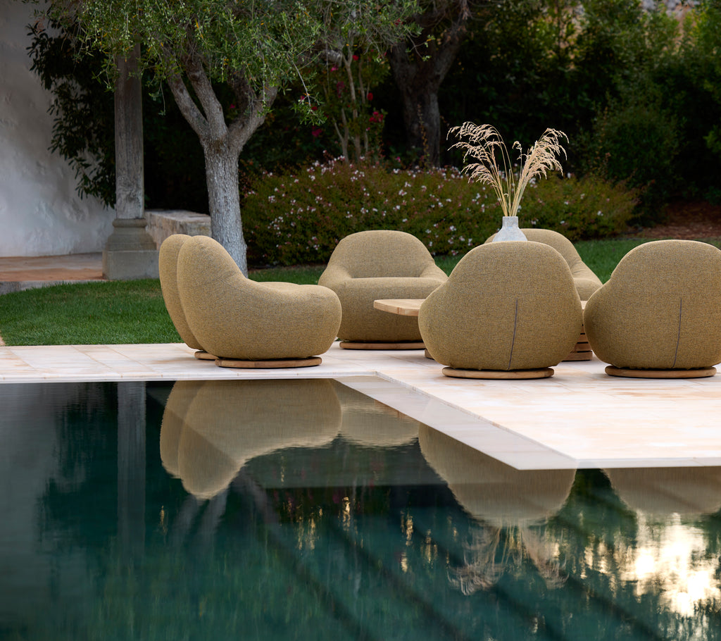 Modern beige chairs arranged around a pool in an outdoor setting.