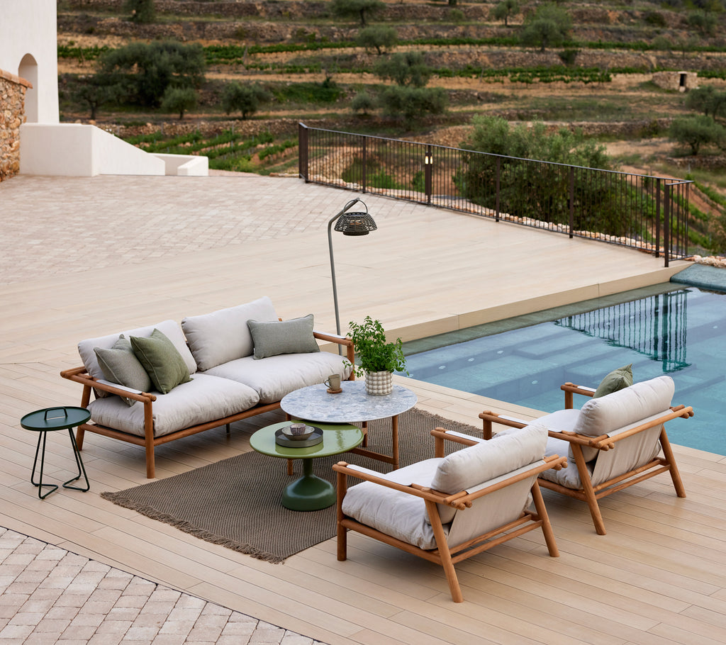 Cozy lounge area featuring a knit rug, stylish seating, a small table, and a floor lamp near a pool with scenic views.