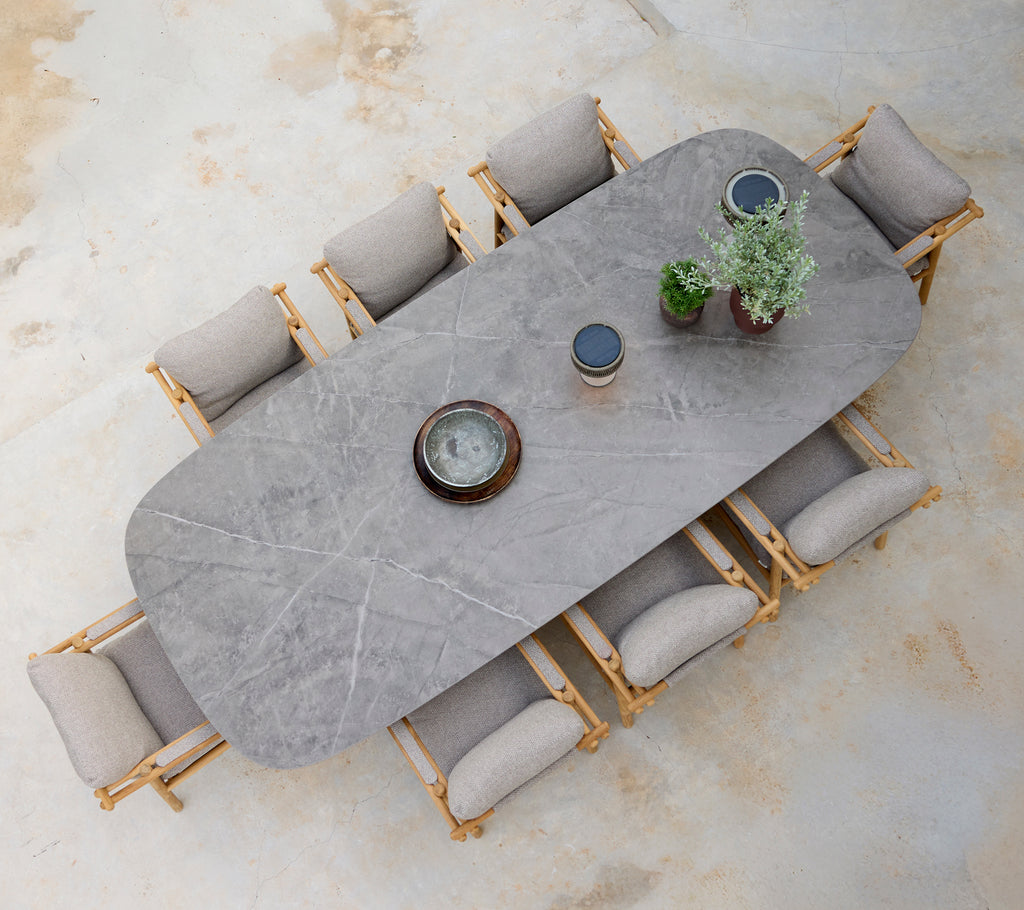 Modern dining setup featuring a grey table with beige cushions and wooden chairs.