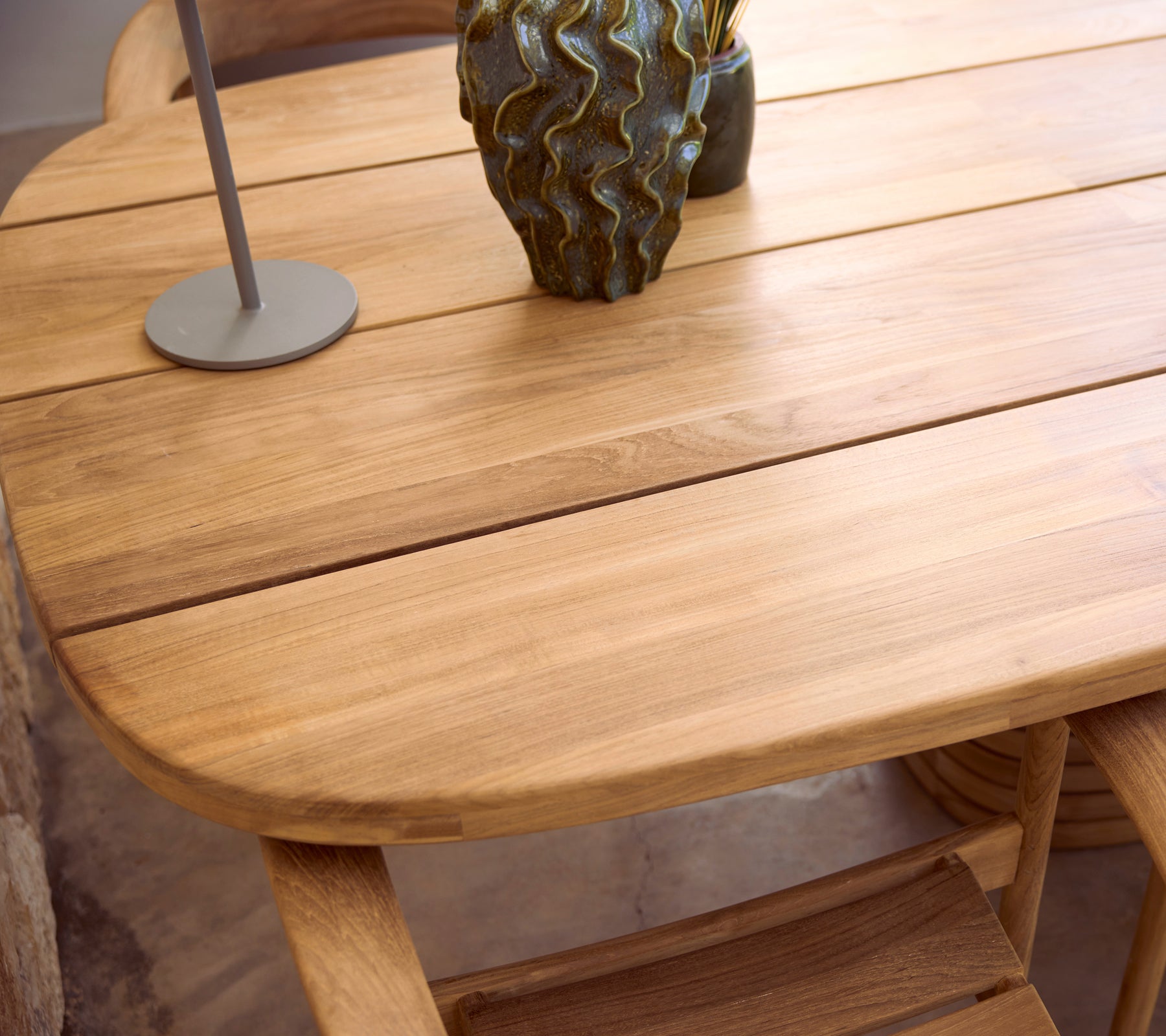 Modern wooden table with a lamp and decorative vase.