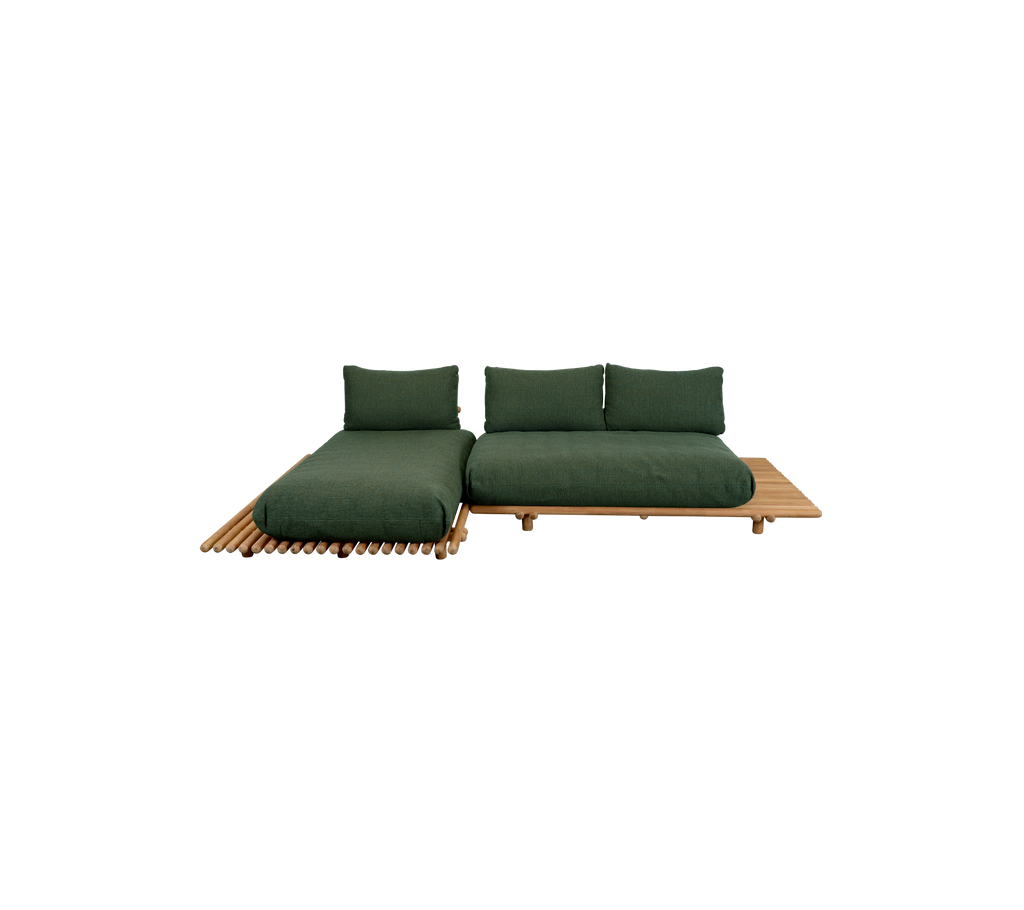 Modern dark green couch with a teak base in a lounge setting.
