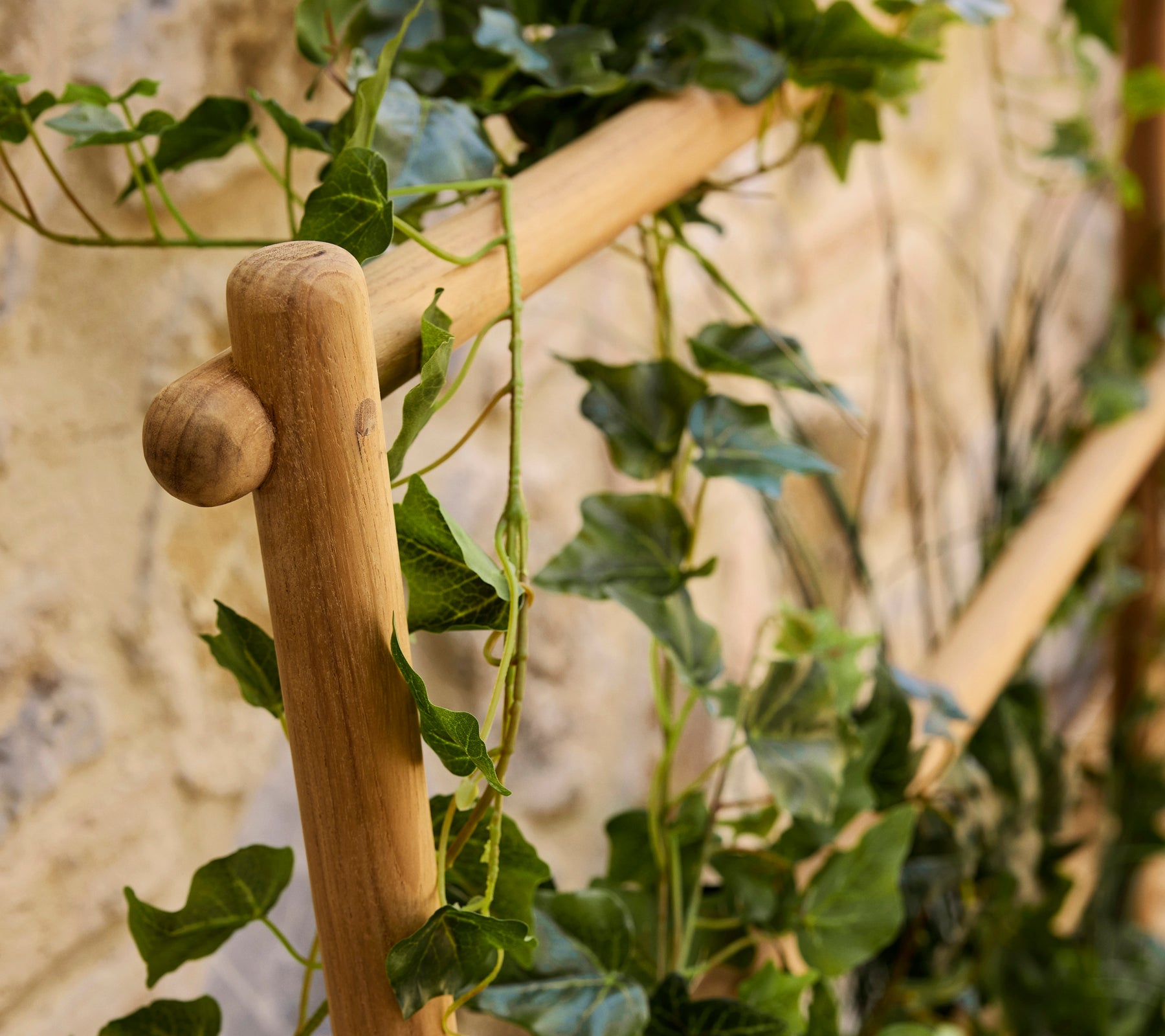 A wooden stick planter featuring lush green vines cascading down, adding a natural touch to the display.