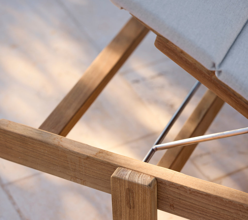 Modern lounge chair with a grey cushion and wooden frame.